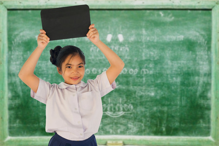Cute student hold board in classroomの写真素材
