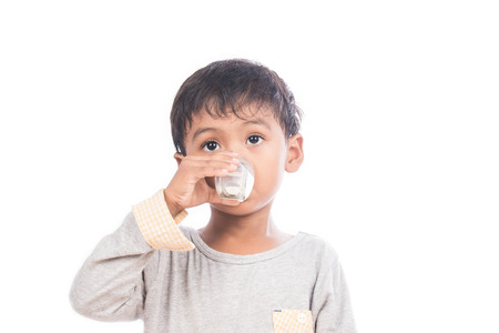 Cute little boy drinking milkの写真素材