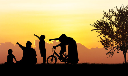 Silhouette of Happy family playing in field sunset backgroundの写真素材
