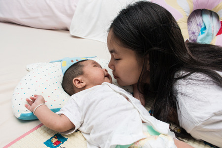 Sister take care her sister on the bedの写真素材