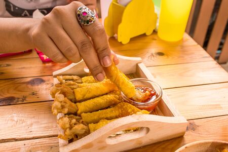Golden needle mushroom with wonton fried on wooden dishの写真素材