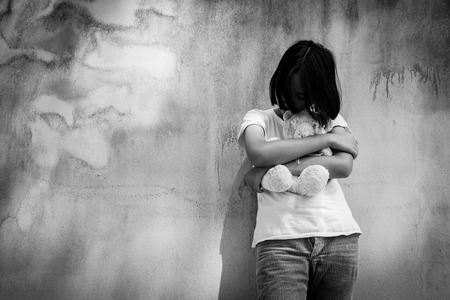 sad asian girl alone with white bear near old wall cement,Teen problem,women sorrow, black and white toneの写真素材