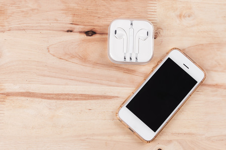 Beauty smartphone and headphones on wooden backgroundの写真素材