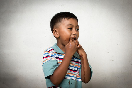 Cute little boy dirty  after eating ice creamの写真素材