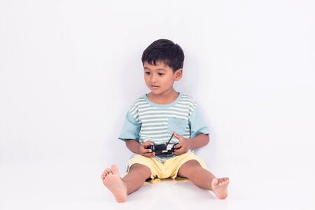 cute little boy play semi-automatic toy car on white backgroundの写真素材