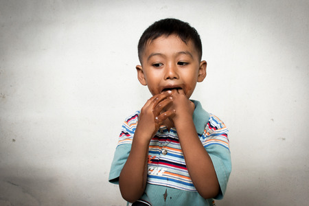 Cute little boy show dirty hand after eating ice creamの写真素材