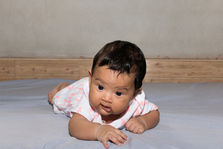 cute asian baby lying on bedの写真素材