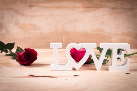 concept valentine day,red rose and test love on brown wooden background,vintage toneの写真素材