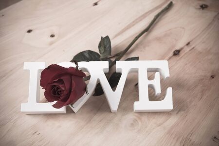 concept valentine day,red rose and test love on brown wooden background,vintage toneの写真素材