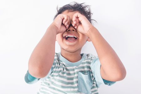 Cute asian little boy lying on floor and cry on white backgroundの写真素材