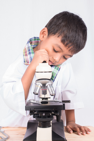cute asian little student boy working with microscopeの写真素材
