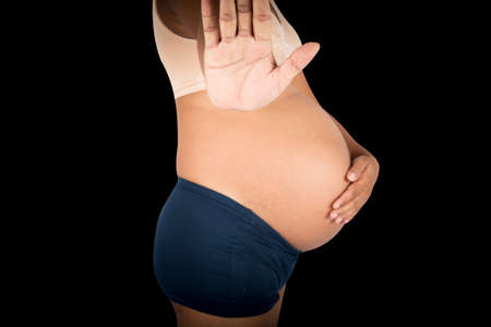 Pregnant women show hand stop on gray backgroundの写真素材