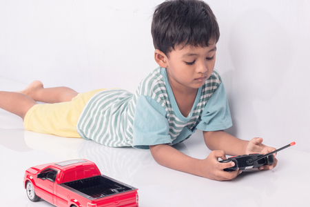 cute little boy play semi-automatic toy car on white backgroundの写真素材