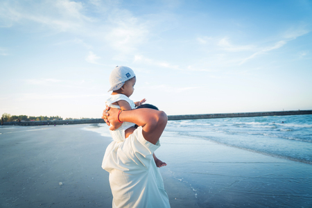 Happy Dad and son play on the beachの写真素材