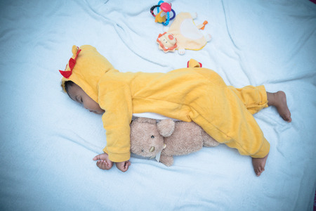 Cute little asian baby sleeping with teddy bear,vintageの写真素材