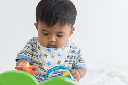 Cute asian baby sitting and play wooden toysの写真素材