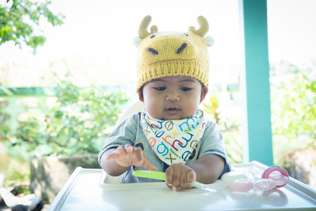 Cute asian little baby eating foodの写真素材