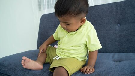 Cute little boy looking at his foot