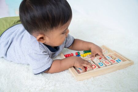 cute little asian baby boy playing with wooden toyの写真素材