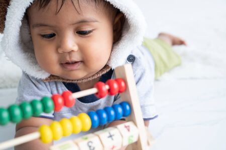 cute little asian baby boy playing with wooden toy