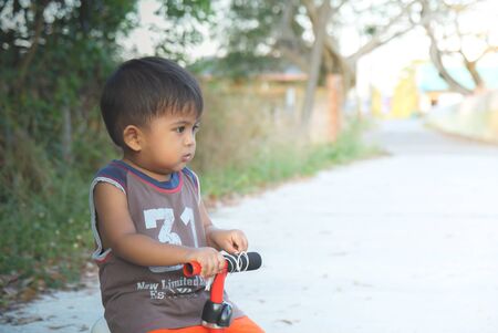 Boy playing a bicycle using a plowed legの写真素材