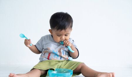 Cute little asian baby boy with spoonの写真素材