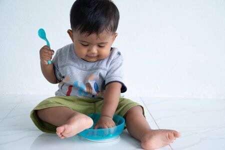 Cute little asian baby boy with spoon
