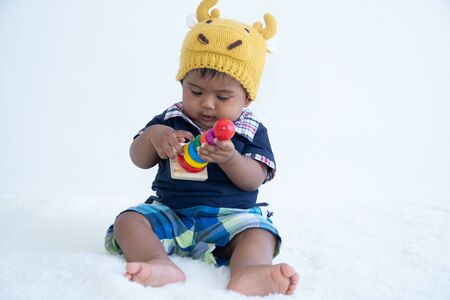 Cute little asian baby boy sitting and play toyの写真素材