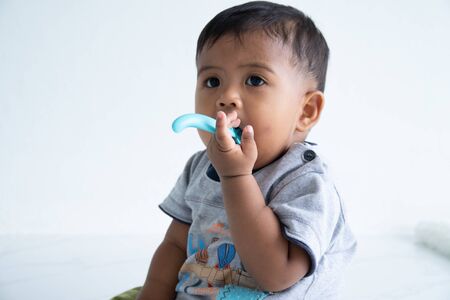 Cute little asian baby boy with spoonの写真素材