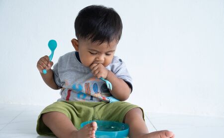 Cute little asian baby boy with spoon