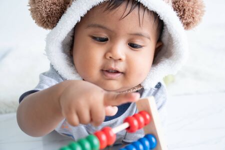 cute little asian baby boy playing with wooden toyの写真素材