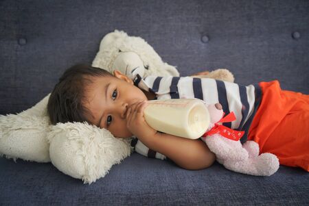 Boys drinking milk from bottlesの写真素材
