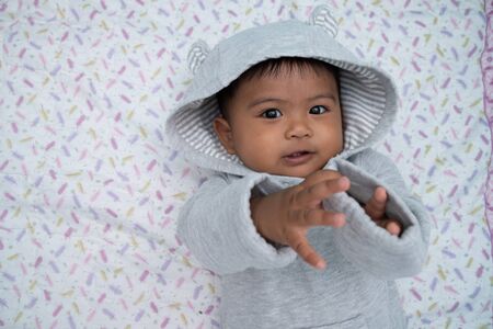 Cute little asian baby boy lying on soft blanketの写真素材