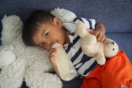 Boys drinking milk from bottlesの写真素材