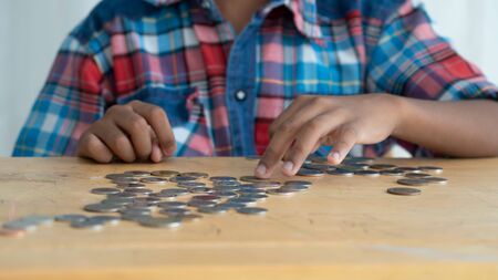 Cute little asian boy with piggy bankの写真素材