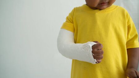 Cute boy hand bone broken from accident with arm splintの写真素材