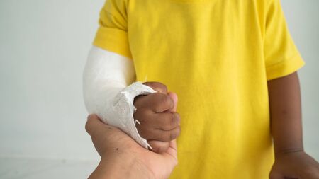 Cute boy hand bone broken from accident with arm splintの写真素材