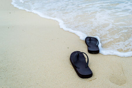slippers on a sandy beachの写真素材