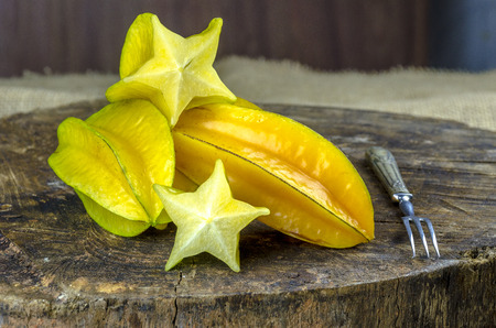 Fresh, juicy and ripe star fruits on a wooden background.の写真素材