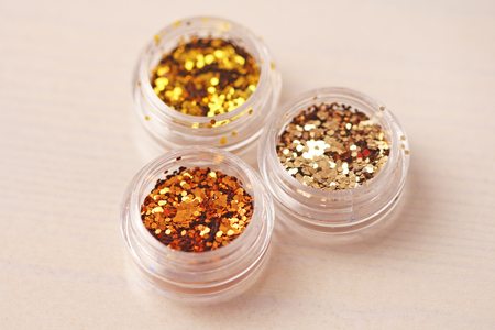 Gold Sequins for the design of nails in a box. Glitter in jars. Foil for nail service. Photo set. Sparkling beauty shimmer, glitter.の写真素材