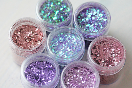 Multi-colored Sequins for the design of nails in a box. Glitter in jars. Foil for nail service. Photo set. Sparkling beauty shimmer, glitter.の写真素材
