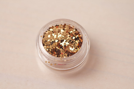 Gold Sequins for the design of nails in a box. Glitter in jars. Foil for nail service. Photo set. Sparkling beauty shimmer, glitter.の写真素材