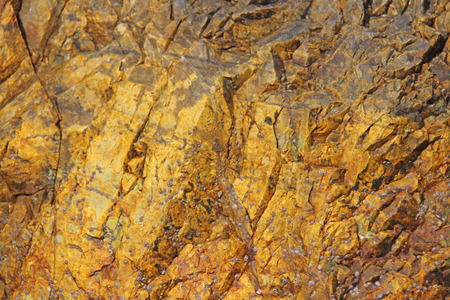 Background stone. Orange, beige or yellow stone for background. Beautiful stone structure or texture. Design with copy space.の写真素材