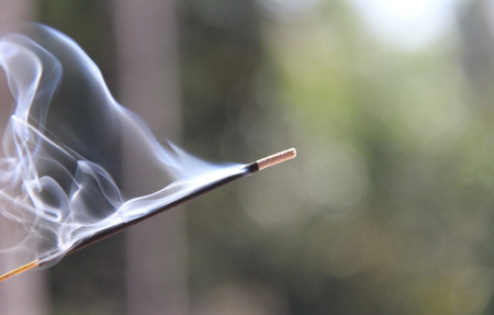 Incense stick and smoke from incense burning. Beautiful smoke. Blurred background and design with copy space.の写真素材