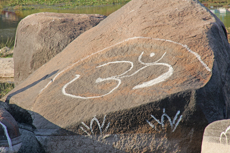 The OM symbol is painted white on a large rock in Hamri, on the river Tungabhadra.の写真素材