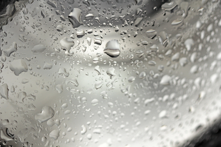 Drops of Rain or Water Drop on the Hood of the Car. Rain Drops on the Surface of the Car or on the Iron Surface Flow Down. Abstract Background and Water Texture for Design.の写真素材