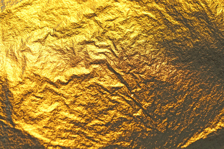 Golden shiny background. Bright golden background, sparkles and shines. A brush stroke.Foil.の写真素材