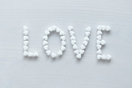 The word love is lined or written from white hearts on a white background. Design with copy space. Top view.の写真素材