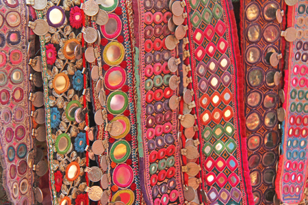 Colorful ethnic belts with mirrors at market in GOA, India. Tibetan souvenirs.