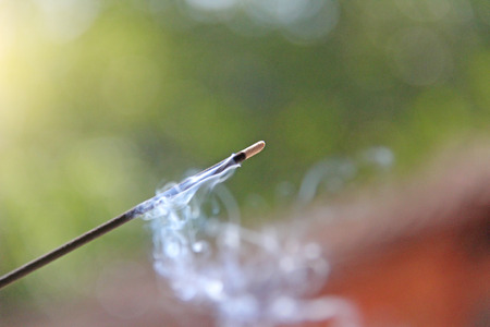 Incense stick and smoke from incense burning. Beautiful smoke. Blurred background and design with copy space.の写真素材